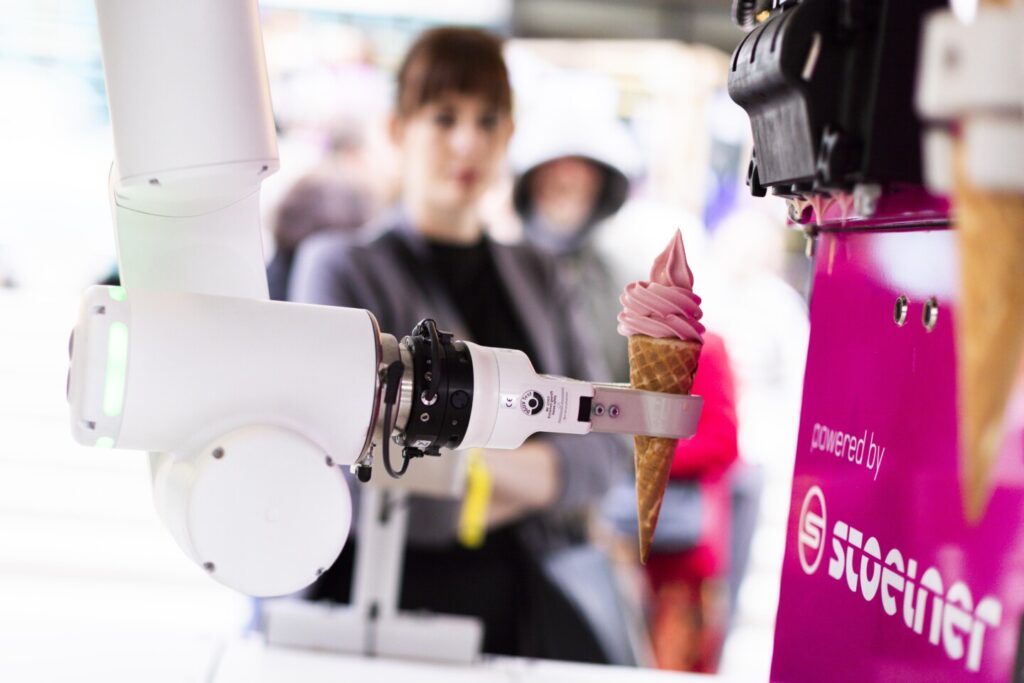 Der Eisroboter fertigt ein Eis für eine Kundin beim Open Tabakfabrik Day an.