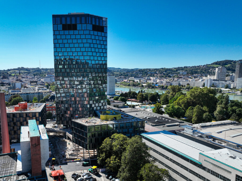 Das Areal der Tabakfabrik mit dem Quadrill-Tower bei strahlendem Sonnenschein. Drohnenaufnahme.