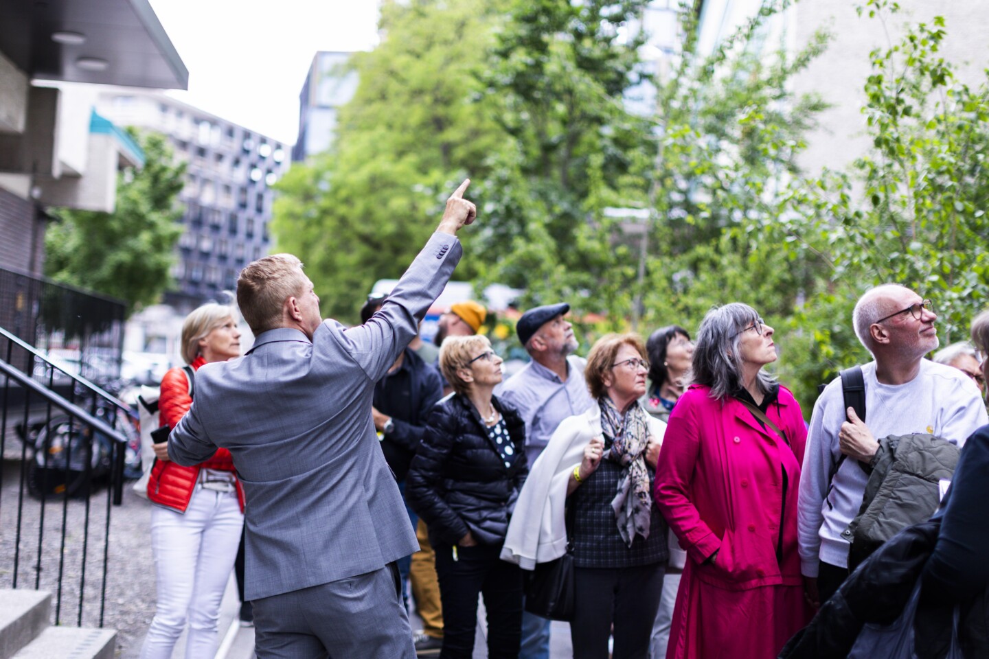 Eine Gruppe Menschen hört einem Guide zu, der die Gruppe quer durch die Tabakfabrik Linz führt.