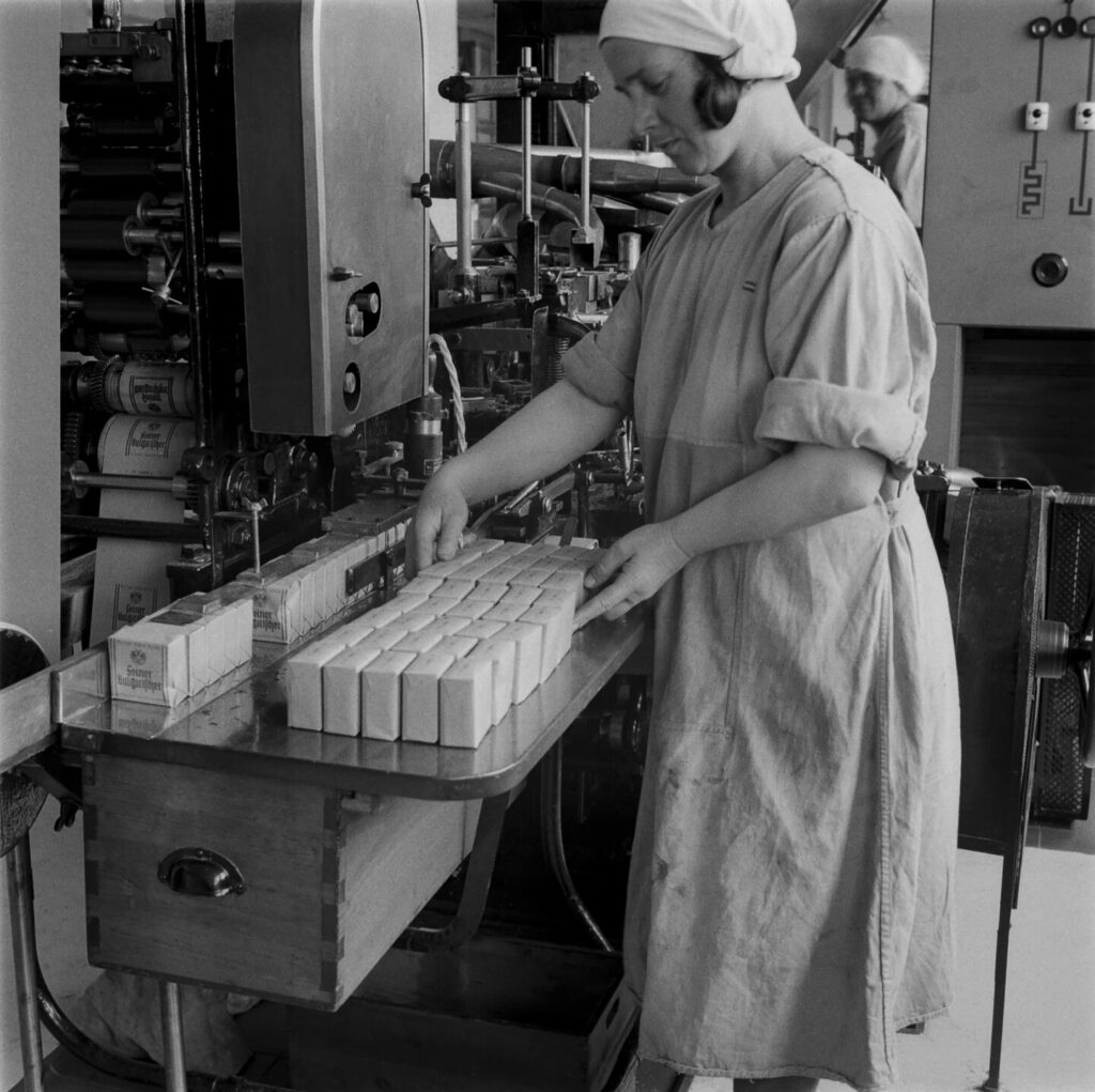 Arbeiterin verpackt Zigaretten um 1936 in der Tabakfabrik Linz