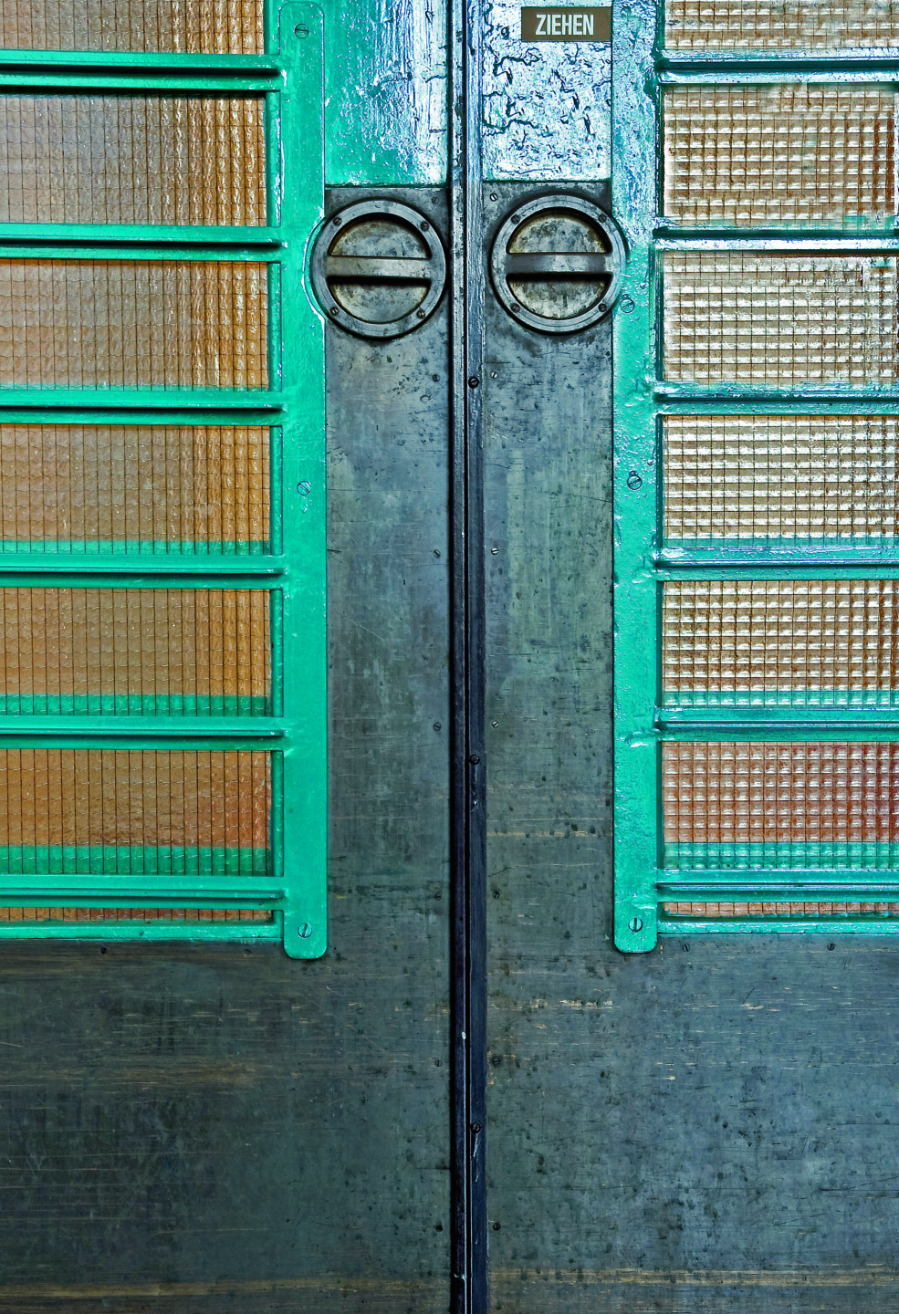 Detailaufnahme der Handgriffe einer Doppeltür aus Drahtglas im "Linzer Blau".
