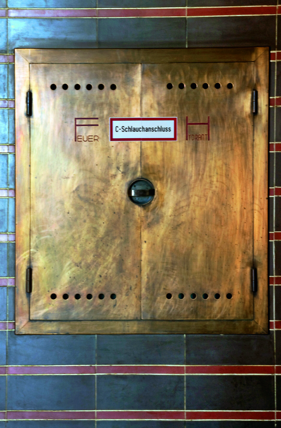 Detailaufnahme der Abdeckung für einen Schlauchabschluss. Die Architekten entwarfen die originale Schrift: "Feuer" "Hydrant".