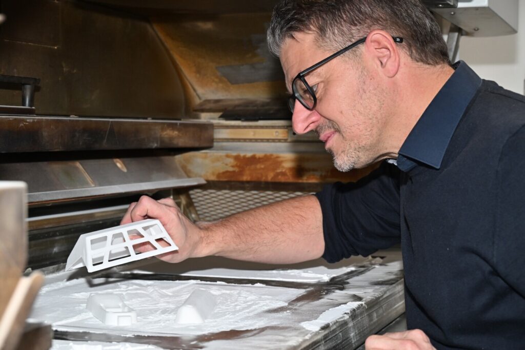 Manfred Haiberger, Geschäftsführer von Kunststoff-Systemlieferant, bei der Arbeit, 3D-Druck Prototypen betrachtend.